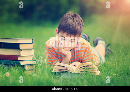 A sette anni di età bambino la lettura di un libro Foto Stock