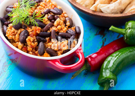 In casa spezzatino piccante con peperoncino, la carne e i fagioli borlotti. Una pentola di chili con carne serviti con mais tortilla chips Foto Stock