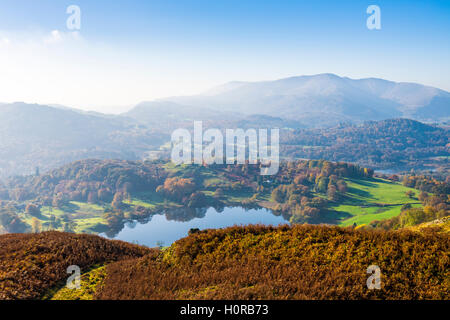 Loughrigg Tarn visto dal Loughrigg cadde con Wetherlam al di là. Lake District. Cumbria. In Inghilterra. Foto Stock