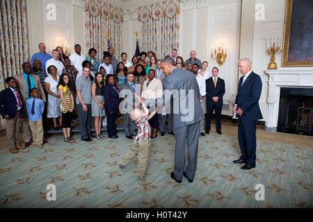 Stati Uniti Il presidente Barack Obama ad alta cinque un ragazzino come lui e U.S. Vice presidente Joe Biden salutare combattenti feriti e le loro famiglie durante un tour della East stanza Giugno 23, 2014 a Washington, DC. Foto Stock