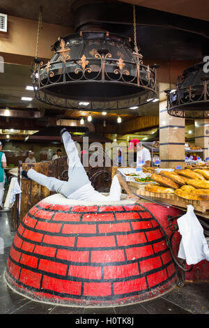 La cottura della tradizionale georgiano armeno / il pane nel forno chiamato tonir in Aparan, Armenia Foto Stock