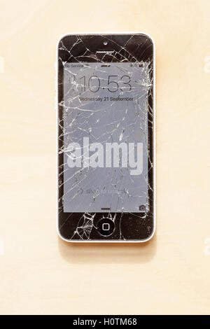 Telefono fracassato. IPhone danneggiato con uno schermo incrinato. Rotto il telefono cellulare. Foto Stock