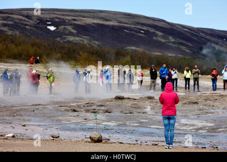 I turisti stanno intorno in attesa per la strokkur geyser a scatenarsi geysir Islanda Foto Stock