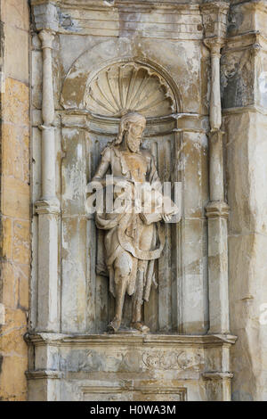 Statua di San Giovanni Battista in una nicchia della facciata della vecchia cattedrale di Coimbra, Portogallo Foto Stock