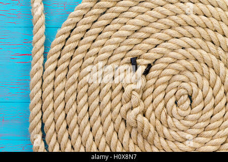 Spesso in corda avvolta a forma di spirale incrinato su pannello di legno con uno sfondo con spazio di copia Foto Stock