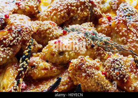 Ali di pollo marinato con pomodoro e salsa di miele. Al forno con semi di sesamo. Foto Stock