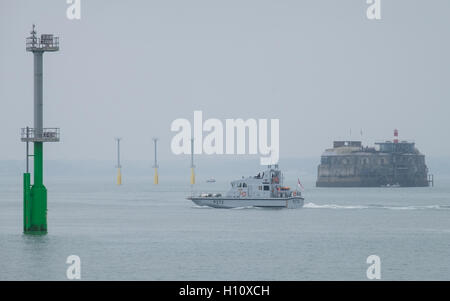 HMS Smiter (P272) vele al di fuori del porto di Portsmouth oltre la navigazione di pali della luce che sono stati installati nel Solent. Foto Stock