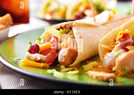 Le fajitas di pollo con verdure e salsa su una piastra verde sul tavolo di legno vicino fino Foto Stock