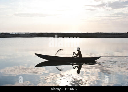 Uomo in barca nel canale di Pangalanes. In background, l'Oceano Indiano è visibile ( Madagascar). Foto Stock
