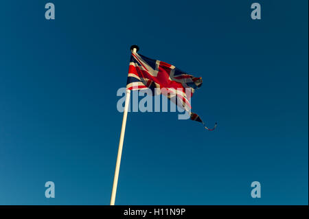 Strappati Union Jack flag contro il cielo blu Foto Stock