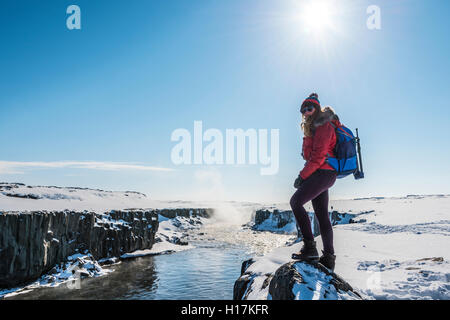 Donna che guarda in telecamera, Hafragilsfoss cascata in inverno, Nordest, Islanda Foto Stock