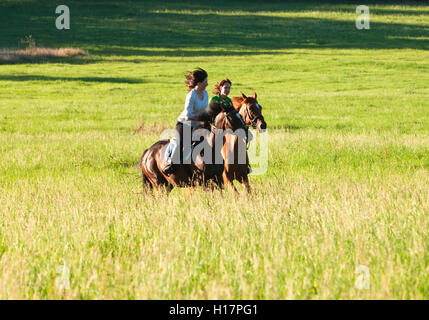 Due Donne Equitazione in un paesaggio Foto Stock