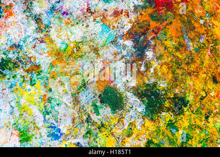 Colorato modello astratto fatto di un essiccata vernice di olio su una superficie di un artista della tavolozza. Giallo, colori verde e bianco Foto Stock