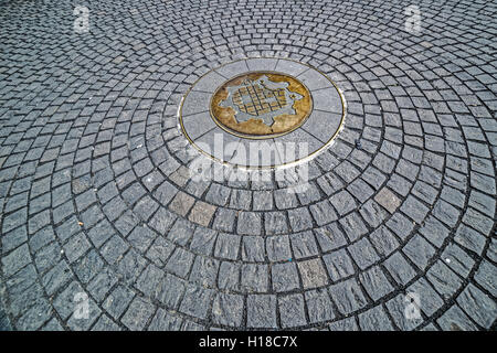 Sfondo con ciottoli, seduti in cerchio e avente al centro il simbolo di Timisoara, Romania, che rappresenta la mappa di Foto Stock