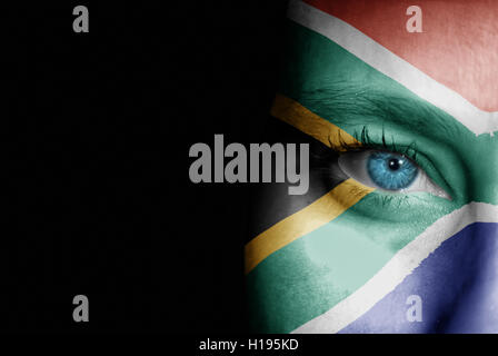 Una giovane donna con la bandiera del Sud Africa dipinte sul suo viso sul suo modo ad un evento sportivo per mostrare il suo supporto. Foto Stock