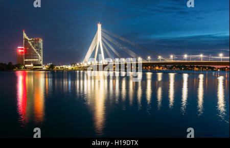 Riga, Lettonia. La vista panoramica di Vansu Cable-Stayed Ponte In brillante illuminazione serale oltre il Fiume Daugava o Western DVI Foto Stock