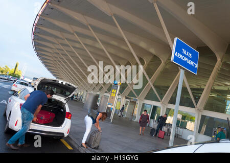 L'aeroporto di Bilbao, Spagna. BIO. Lo scarico dei bagagli da un taxi di fronte al terminal Foto Stock