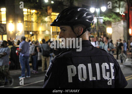 Charlotte, Stati Uniti d'America. Il 22 settembre, 2016. Un funzionario di polizia sta di guardia come le persone prendono parte a una manifestazione di protesta a Charlotte, North Carolina, Stati Uniti, Sett. 22, 2016. Un coprifuoco ordine è stato rilasciato negli Stati Uniti città di Charlotte giovedì notte come centinaia di manifestanti hanno marciato in modo relativamente pacifico attraverso il centro cittadino per protestare contro la polizia fatale riprese di un uomo nero per la terza notte. Credito: Lu Jiafei/Xinhua/Alamy Live News Foto Stock