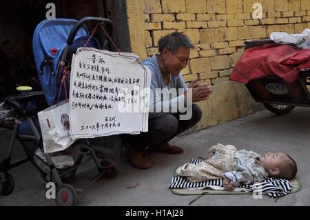 Settembre 22, 2016 - Zhumadian, Zhumadian, Cina - Zhumadian, CINA-Settembre 22 2016:?(Editorial?uso?Solo.?CINA?OUT) Zhou Xuelian, un 63-anno-vecchia donna, vive con suo nipote in una squallida casa di Zhumadian, Cina centrale¡Â¯s nella Provincia di Henan. Zhou XuelianÂ¡Â¯s nipote è nato handicappati e abbandonata dai suoi genitori più tardi. Zhou ha deciso di sollevare il bambino con suo marito anche se erano poveri. Ora Zhou e suo marito vivono sul cestino di lavaggio su strada. Un medico ha detto Zhou che occorrerebbero circa 300.000 yuan (US$ 45.000) per curare il bambino. Pertanto Zhou è andato ad una stazione televisiva locale Foto Stock