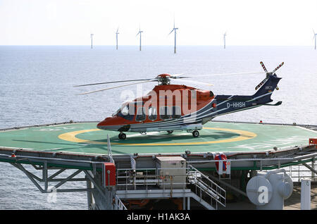 Sylt, Germania. Xxi Sep, 2016. Un AgustaWestland AW139 elicottero è parcheggiata sulla piattaforma di trasformatore vicino al vento offshore park DanTysk svedese di società elettrica Vattenfall e la SWM Monaco di Baviera servizi municipali, circa 43 miglia marine ad ovest dell'isola di Sylt, Germania, 21 settembre 2016. Una cinquantina di ingegneri e tecnici live sulla piattaforma di alloggio poiché due settimane. Essi effettuano lavori di manutenzione sul DanTysk e il Sandbank parchi eolici che si trovano nelle vicinanze. Foto: Christian Charisius/dpa/Alamy Live News Foto Stock