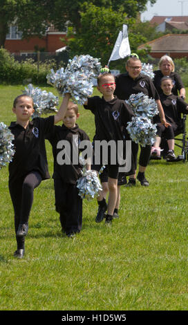 Adolescenti e Bambini cheerleaders in nero con argento pompon Foto Stock