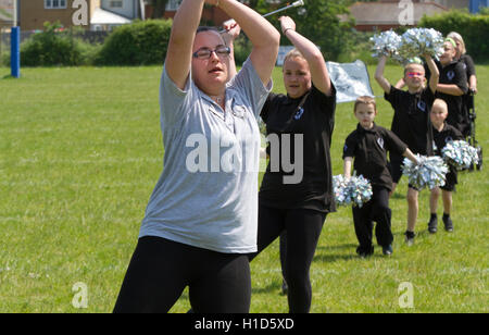 Adolescenti e Bambini cheerleaders in grigio e nero/grigio con pompon Foto Stock