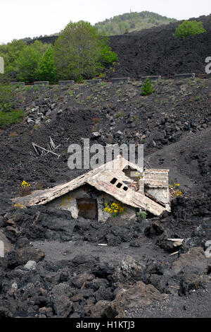 Casa coperte di lava sulle pendici del monte Etna, Sicilia, Italia Foto Stock