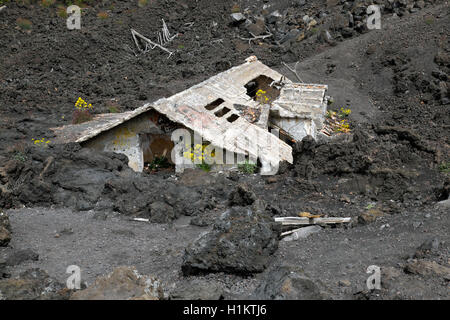 Casa coperte di lava sulle pendici del monte Etna, Sicilia, Italia Foto Stock