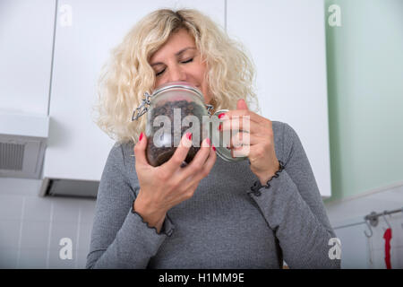 Ragazza bionda con capelli ricci è odore di chicchi di caffè Foto Stock