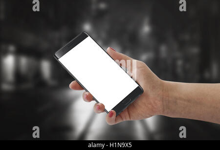 Ragazza moderna mostra black smart phone con il bianco schermo vuoto per mockup. Sfondo nero. Foto Stock