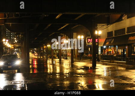 Vista nigthtime del traffico sotto la ferrovia sopraelevata le vie del centro di Chicago sulla notte piovosa Foto Stock