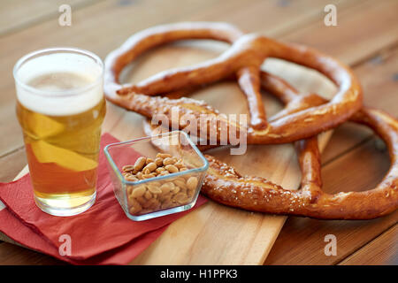 Close up di birra, salatini e arachidi sul tavolo Foto Stock