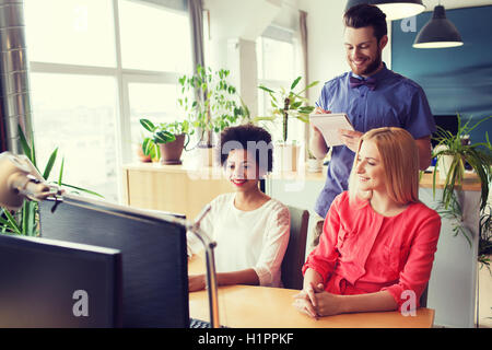 Happy team creativo con il computer in ufficio Foto Stock