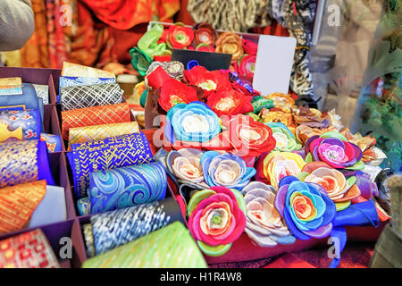 Colorata a mano cravatte e fiore spille visualizzati in corrispondenza di uno degli stalli durante il mercatino di Natale a Riga, Lettonia. Il mercato è tradizione annuale e parte delle celebrazioni tradizionali. Foto Stock