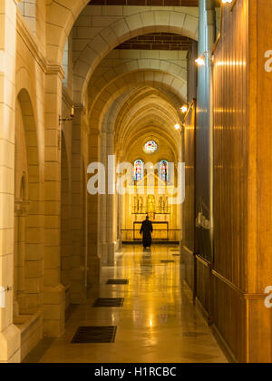 Un monaco assume quotidianamente passeggiata intorno alla stupenda abbazia incorniciato dalla splendida architettura del secolo12th Buckfast Abbey. Foto Stock