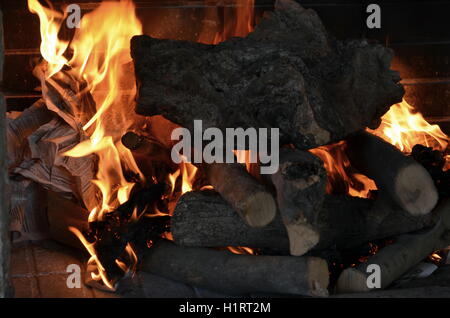 Un grande fuoco che brucia nel camino emette molto calore Foto Stock