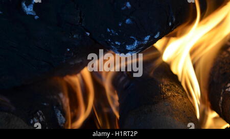 Un grande fuoco che brucia nel camino emette molto calore Foto Stock