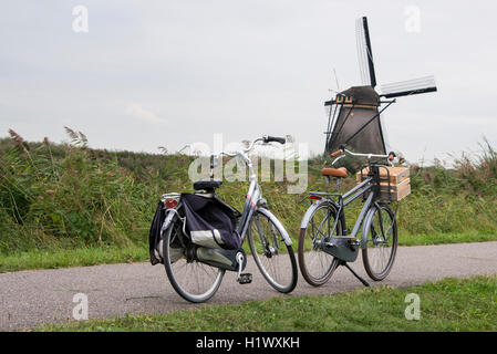 Paesi Bassi (Olanda), Rotterdam. Kinderdijk, sede della più grande collezione di mulini a vento nei Paesi Bassi. Biciclette nella parte anteriore Foto Stock