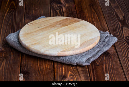 Round tagliere su un tavolo di legno Foto Stock