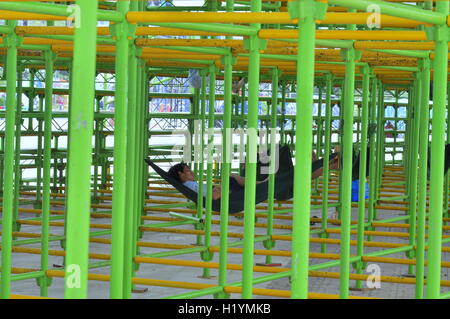 Nha Trang, Vietnam - Luglio 11, 2015: i lavoratori stanno dormendo in costruzione impalcature in piazza Foto Stock