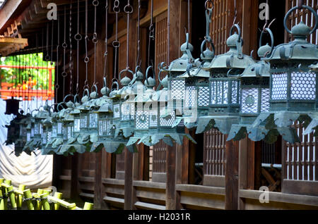 Molti acciaio nero lanterne appese intorno alla chiesa in legno di Kasuga a Nara, Giappone Foto Stock