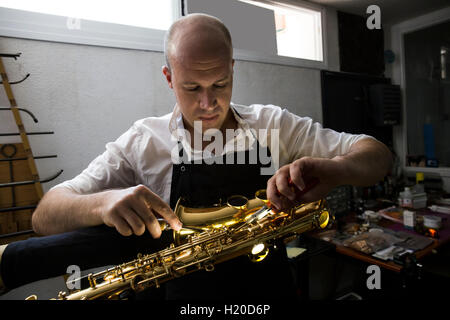 Strumento di smontaggio maker un sassofono durante una riparazione Foto Stock