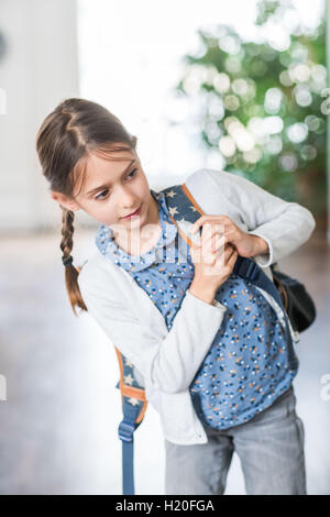 9 anno-vecchia ragazza sulla strada per la scuola. Foto Stock