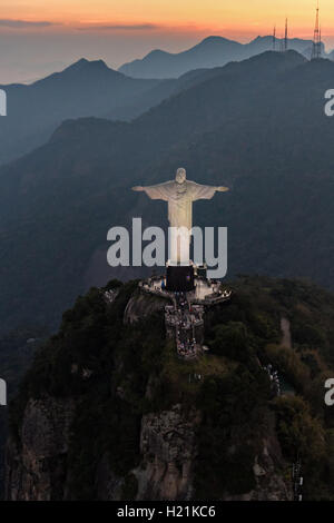 Cristo Redentore statua sul monte Corcovado guardando verso le montagne al tramonto a Rio de Janeiro in Brasile. Foto Stock