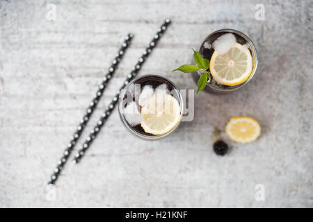 Blackberry limonade con limone e cubetti di ghiaccio in bicchieri Foto Stock
