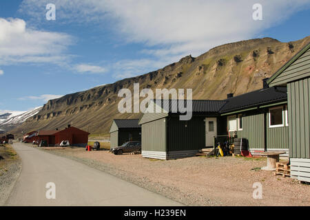 L'Europa, Norvegia, Isole Svalbard (Spitsbergen), Longyearbyen, Main Street con i tipici edifici e delle montagne innevate dietro Foto Stock