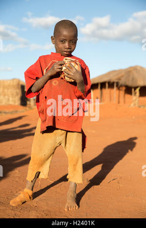Villaggio Namina, Nampula Provincia, Mozambico, Agosto 2015: un giovane ragazzo detiene una palla a mano da lui i suoi amici sono stati a giocare con. Foto Stock