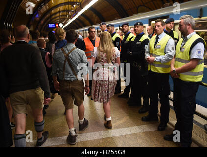 Monaco di Baviera, Germania. 23 Sep, 2016. I visitatori a piedi passato guardie di sicurezza presso il "Theresienwiese' la stazione della metropolitana di Monaco di Baviera, Germania, il 23 settembre 2016. Il 183rd Oktoberfest si svolge dal 17 settembre al 03 ottobre 2016. Foto: FELIX HOERHAGER/dpa/Alamy Live News Foto Stock