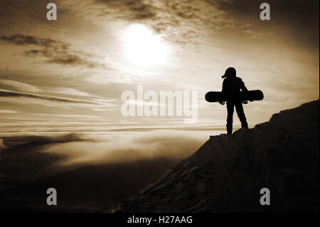 Gli appassionati di snowboard in posa sul cielo blu sullo sfondo di montagne Foto Stock