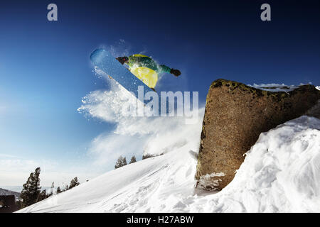 Gli appassionati di snowboard in posa sul cielo blu sullo sfondo di montagne Foto Stock